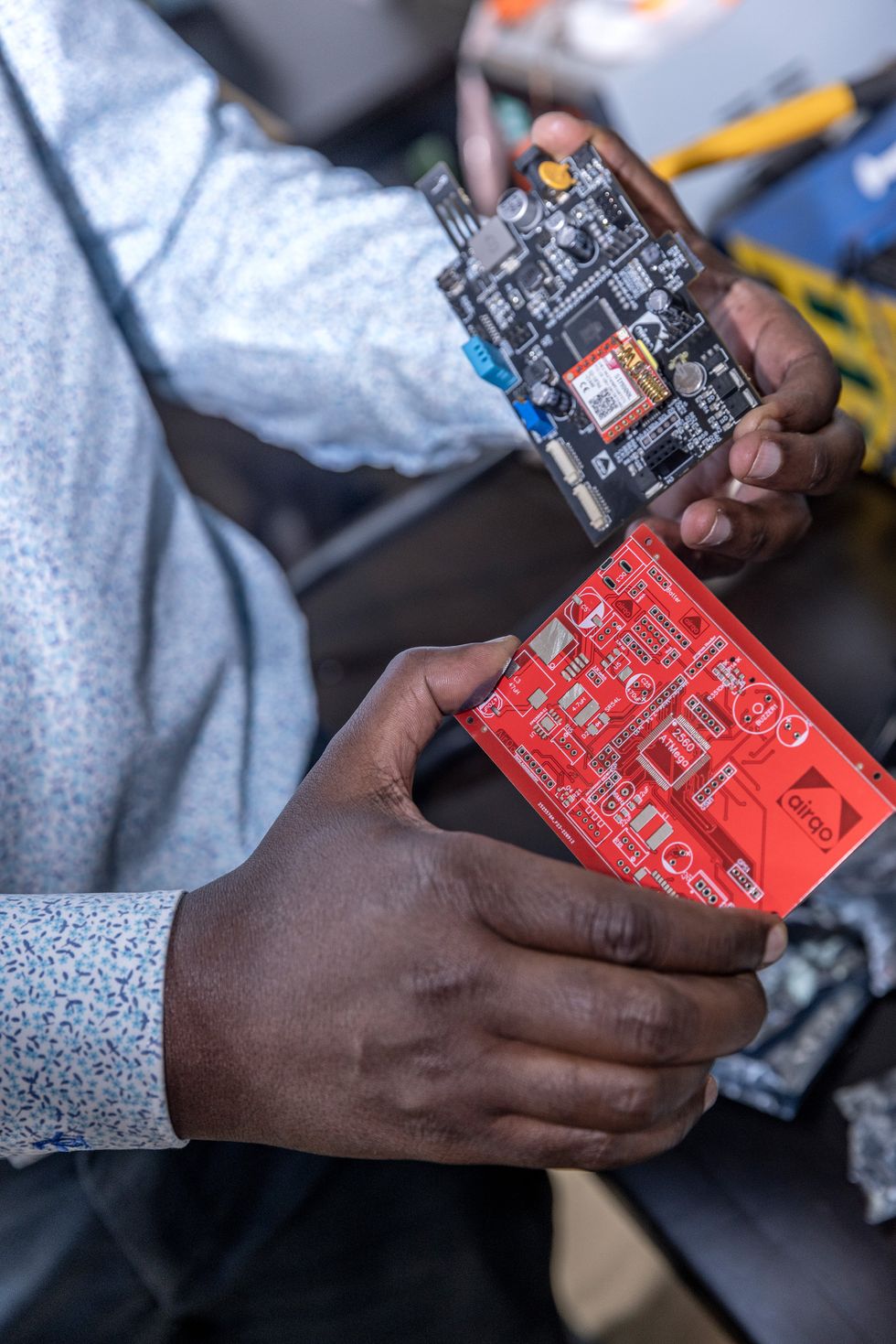 A pair of hands holding two circuit boards.