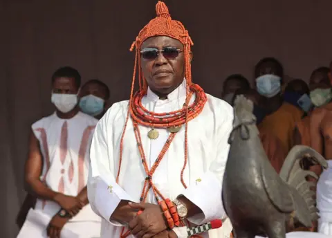 AFP/Getty Images Oba Ewuare II in royal regalia by Benin Bronze cockerel that was returned 
