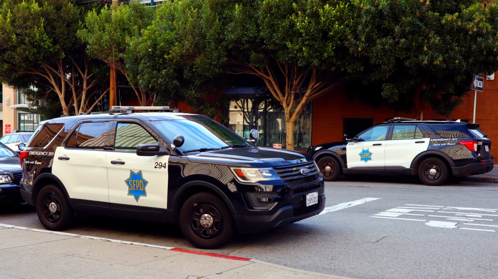 Two San Francisco Police Department (SFPD) cars parked on a city street.