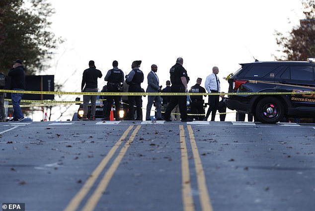 Law enforcement officials stand close to the scene where two West Virginia National Guard members were shot