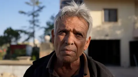 Neha Sharma/BBC An older man with a weathered face and grey hair looks into the camera.