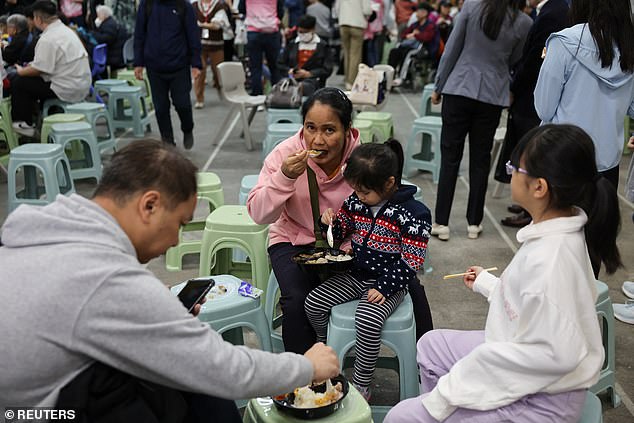 People eat a meal at a temporary shelter, after a fire started across multiple buildings at Wang Fuk Court housing estate, in Tai Po, Hong Kong, China, November 26, 2025