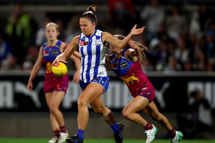 Emma Kearney of the Kangaroos kicks whilst being tackled during the AFLW Grand Final.