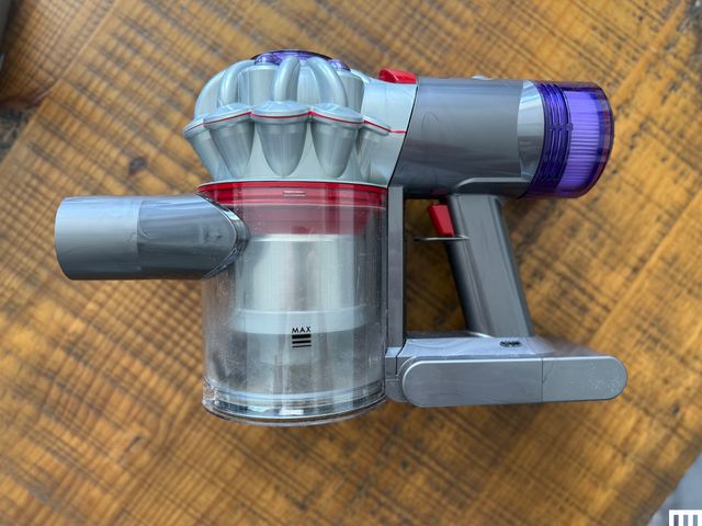 Overhead view of Dyson Car+Boat Handheld Vacuum on top of a wooden table.