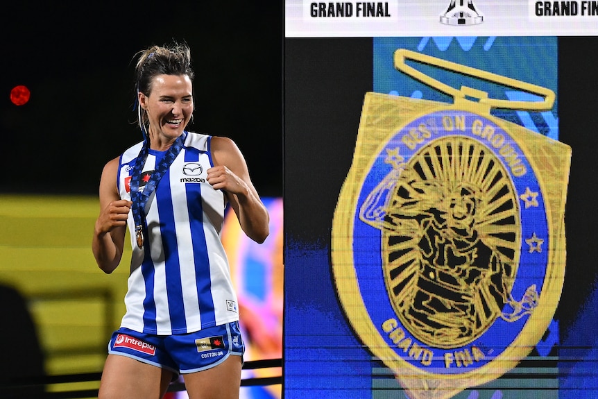 Eilish Sheerin of the Kangaroos reacts on stage after being awarded the best-on-ground medal in the AFLW grand final.