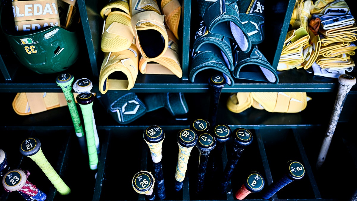 Baseball bats and gloves at the dugout.