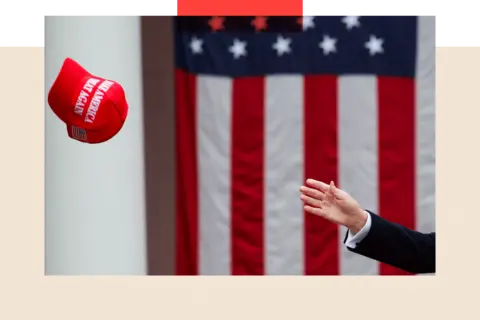 Reuters A hand reaches out and tries to reach a MAGA hat
