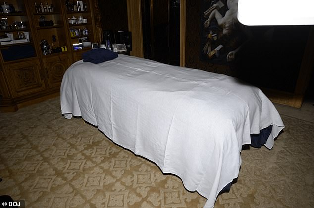 A massage table with a stocked cabinet behind it is pictured in Epstein's home