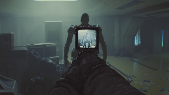 First-person view of the player character aiming a tool at a terrifying robot enemy.