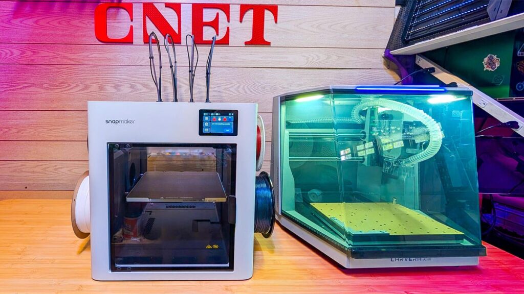 A 3D printer and CNC mill on a table under the CNET logo