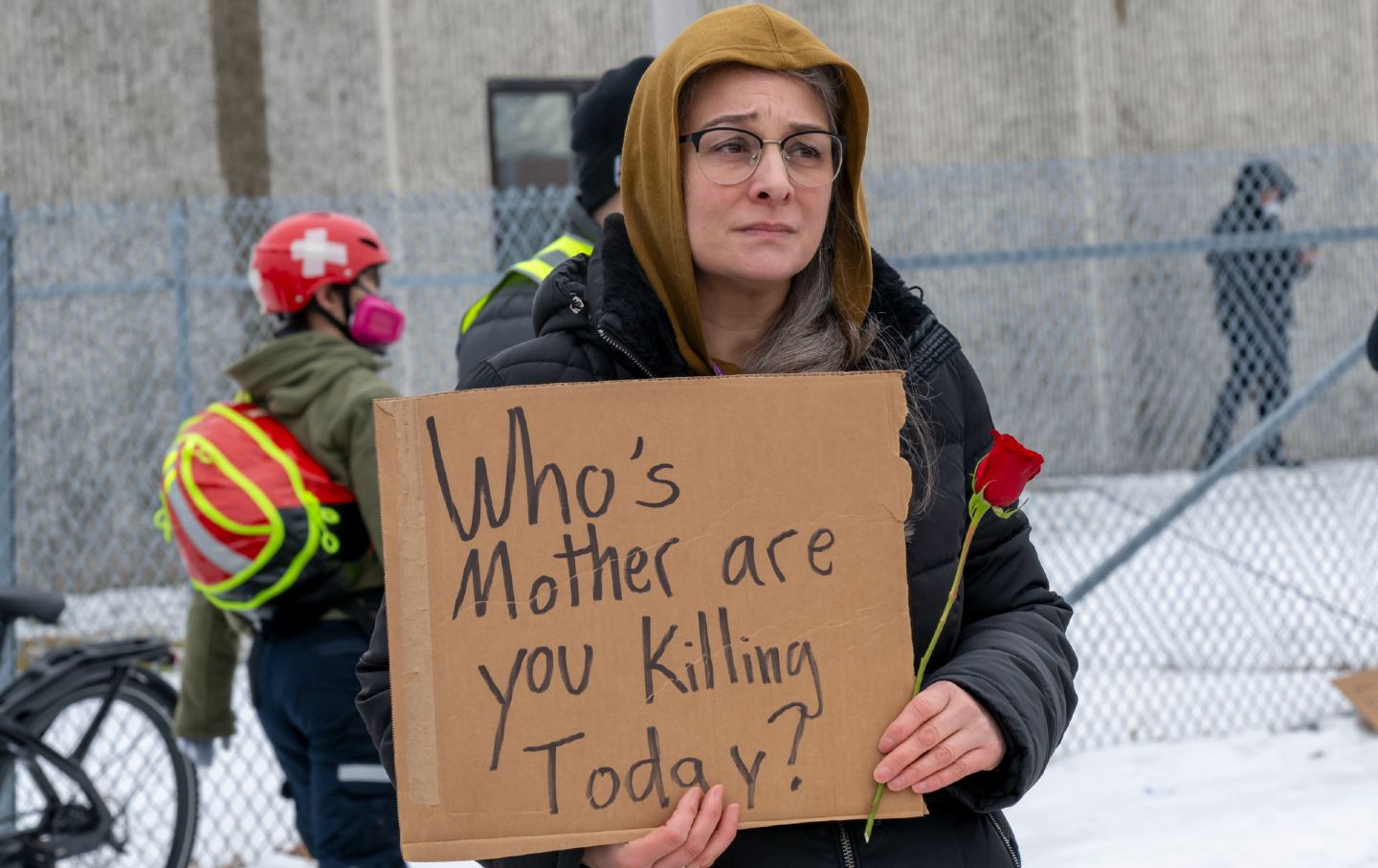 A protester holds a sign in front of the Whipple Federal building in response to an ICE agent’s killing Renee Good.