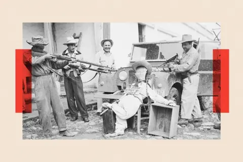 Getty Images A black and white photo shows an effigy of former Guatemalan President Jacobo Arbenz propped against a Jeep as men in hats train guns on it. The effigy has a placard, which says (in Spanish) 