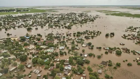 EPA/Shutterstock An aerial view showing flooded neighbourhoods and brown water stretching out into the distance