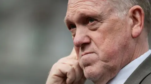 EPA Trump's border czar Tom Homan appears in pensive mood as he hold his hand to his face and stares into the distance in a close-up photo taken in the White House grounds.