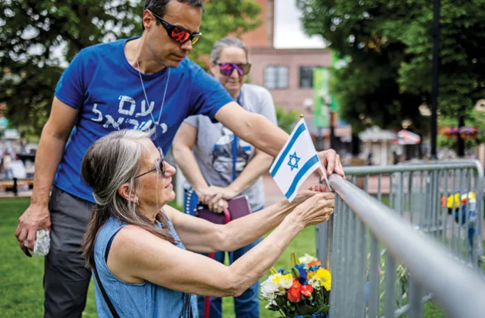 Lisa Turnquist of Louisville, Colorado, lays flowers and an Israeli flag at the site of an attack in Boulder, Colorado, on Jews who were gathered to call for the release of hostages held by Hamas, June 2, 2025. (Chet Strange/Getty)