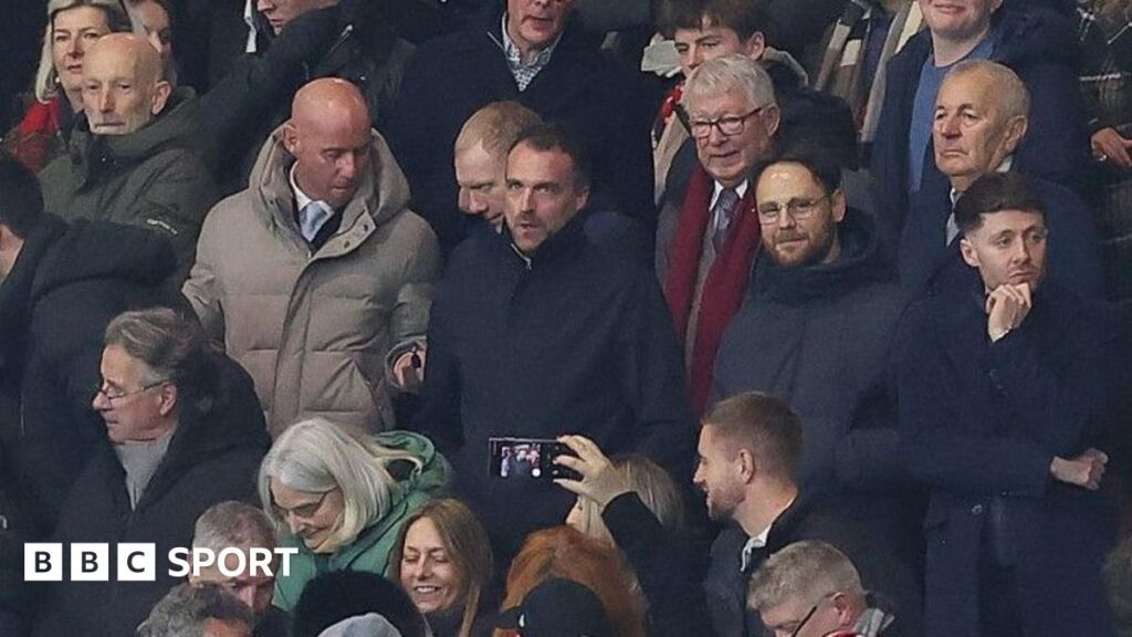 Nicky Butt (grey coat) and Paul Scholes to his left sat with former manager Sir Alex Ferguson (red scarf) at Manchester United
