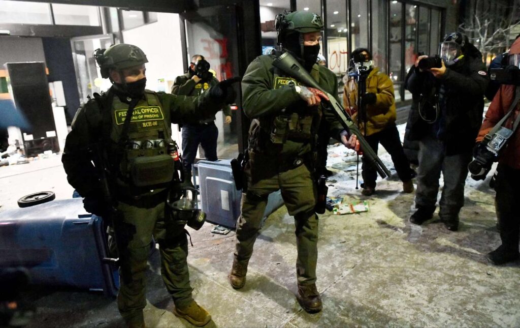 Federal agents push back protesters during the