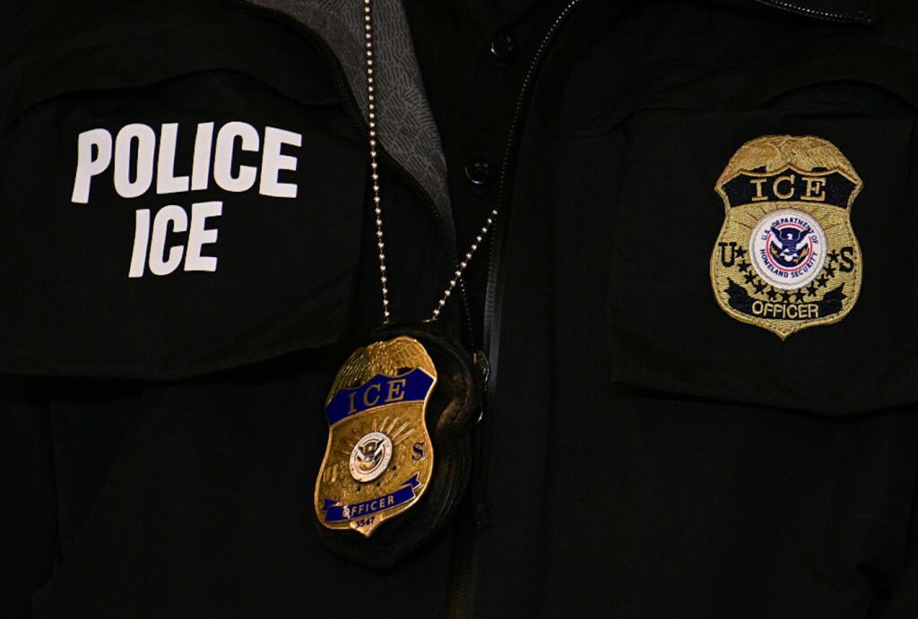 An ICE patch and badge are seen on a DHS agent during Vice President JD Vance