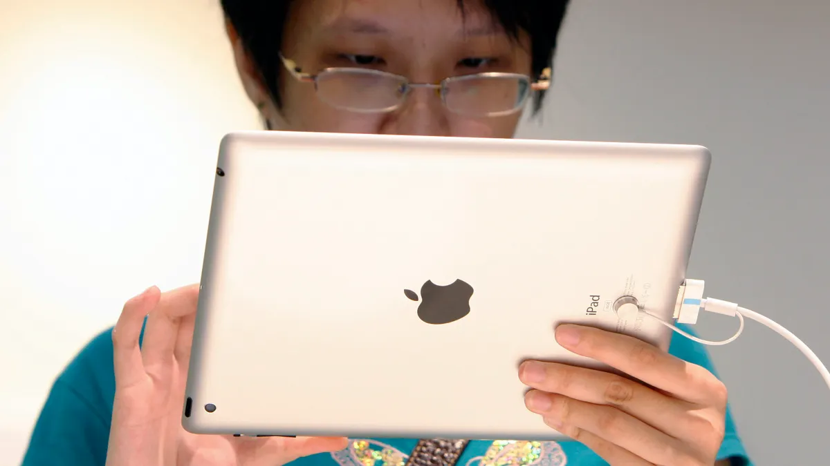 FILE - In this, Friday, April 20, 2012, file photo, a visitor tries out an iPad at an Apple store in Klang, outside Kuala Lumpur, Malaysia. IPads and other other electronic devices containing nickel might cause rashes, according to a Monday, July 14, 2014 report in Pediatrics. Whether all iPad models and other Apple devices contain nickel is uncertain. (AP Photo/Lai Seng Sin, File)