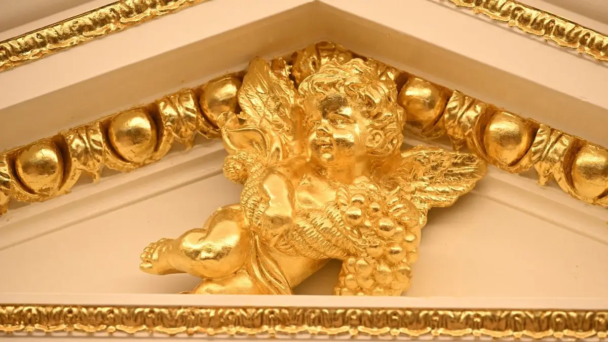 A golden cherub in the door trim of the Oval Office.